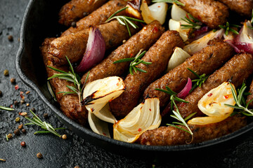 Rosemary and onion vegetarian vegan sausages oven baked in cast iron skillet frying pan