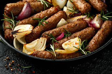 Rosemary and onion vegetarian vegan sausages oven baked in cast iron skillet frying pan