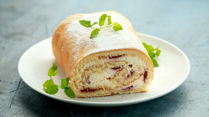 Cream Swiss Roll with strawberry jam on white plate