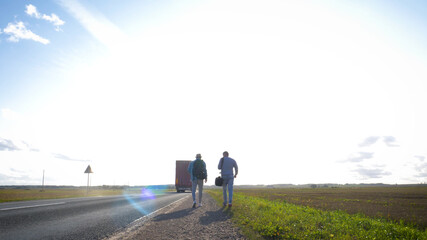 Fototapeta premium Asphalt road on dandelion field with a small truck. lorry moving on sunny evening.