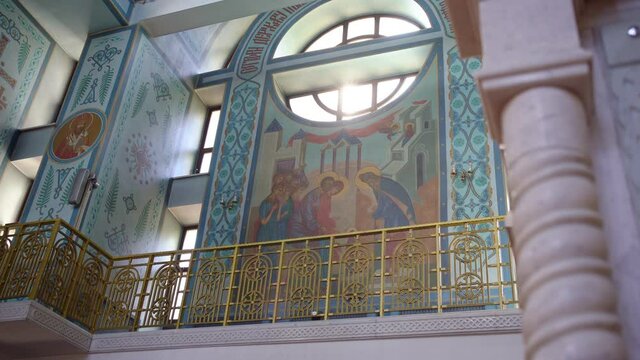 walls of Orthodox Church are painted with icons. sunlight from the Windows.