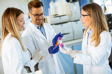 Group of young researchers analyzing chemical data in the laboratory