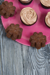 Chocolate cupcakes with cream cheese cream. On pine planks painted black and white.
