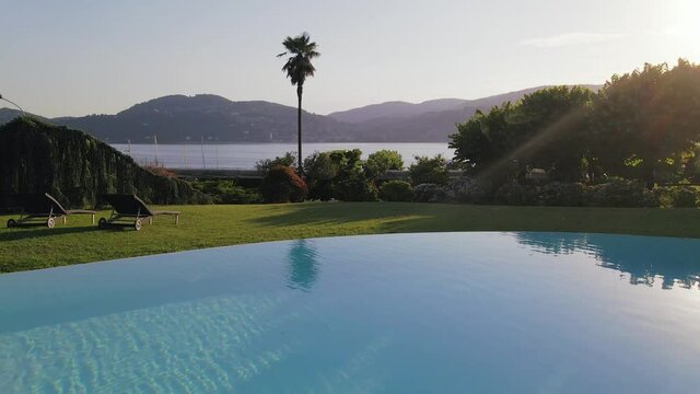 Drone Flies Over Beautiful Luxurious Swimming Pool in The Town Of Ranco on Lake Maggiore in Italy During A Calm Sunset