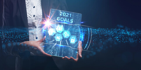Business, Technology, Internet and network concept. Young businessman working on a virtual screen of the future and sees the inscription: 2021 goals