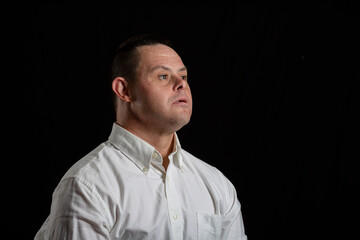 happy man with down syndrome in photo studio on black background