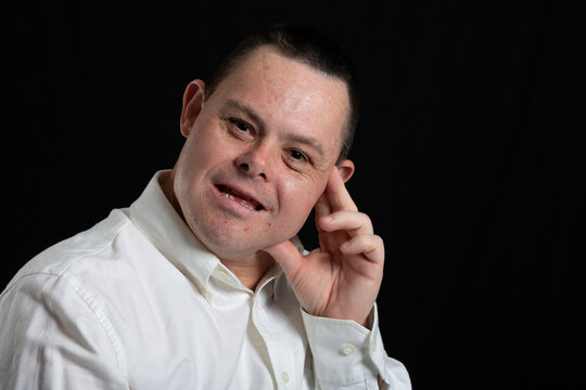happy man with down syndrome in photo studio on black background