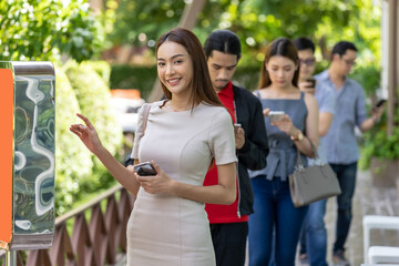 Customer ordering on touch screen kiosk in restaurant.