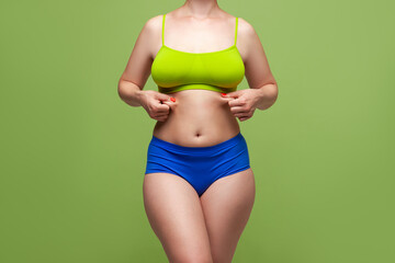 Beauty woman in multicolored underwear on green background