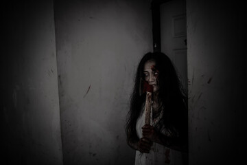 Portrait of asian woman make up ghost face,Horror scene for wallpaper,Scary Halloween festival concept,Ghost holding axe