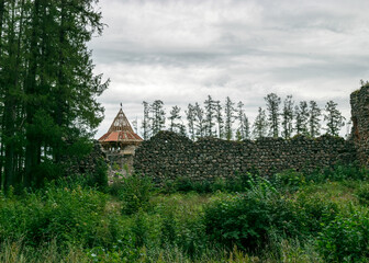 old medieval stone castle ruins, castle tower with new roof structure in the background, Ergeme castle ruins, Latvia