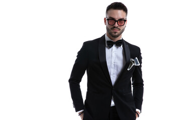 sexy elegant businessman in tuxedo holding hands in pockets