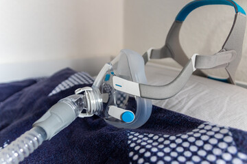 CPAP mask against obstructive sleep apnea on pillow helps patients as respirator mask and headgear clip for breathing medication with a cpap machine against snoring and sleep disorder to breath easier