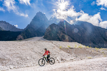 Fototapeta premium pretty senior woman riding her electric mountainbike in the Innerfeld Valley in the Sexten Dolomites near village of Innichen , Tre cime National park, South Tirol, Italy 