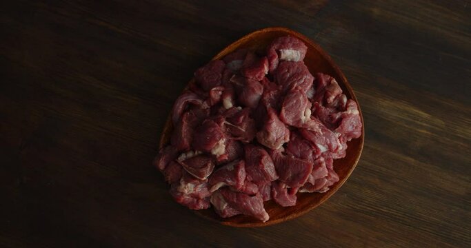 A pile of sliced raw beef on a plate rotates slowly. 