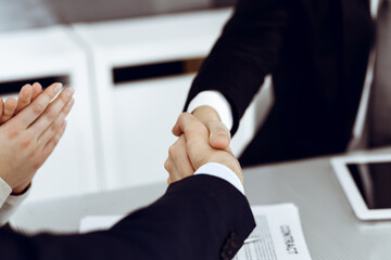 Business people shaking hands after contract signing in modern office. Teamwork and handshake concept