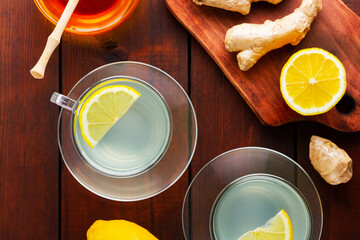 Ginger tea with lemon. Two cups of ginger tea with lemon and honey on wooden background. Top view