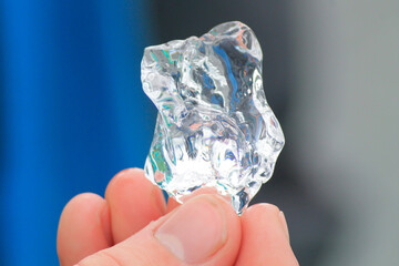 Person holding piece of clear ice