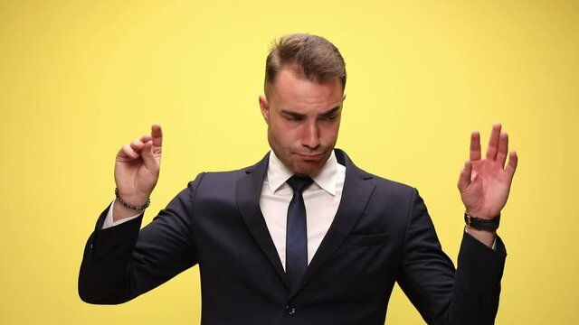 businessman mimicking at first with one talking hand then with the other one, then with both hands that are arguing on yellow background