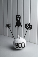 Halloween home decorations. Painted white pumpkin and black Halloween scary shadow puppets on...
