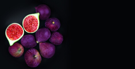 Fresh ripe figs on a black plate over dark background,  top view. Copy space