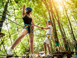 Obraz premium Young couple having fun time in adventure rope park.