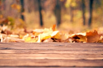 Empty wooden table autumn leaves nature bokeh background with a country outdoor theme,Template mock up for display of product