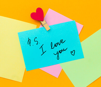 multicolored paper notes with text ps i love you  with cloth pin decorated with red heart
