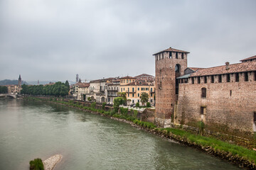 View from the Scaliger bridge of the Adige river, the Old castle, the bell tower of the Cathedral and the Cathedral of St. Anastasia in Verona. Veneto, Italy