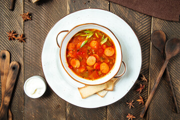Hot sausage tomato soup in a white bowl 