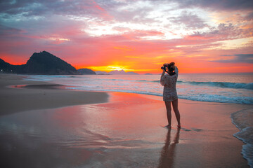 girl photographer at sunrise on Copacabana beach. Rio