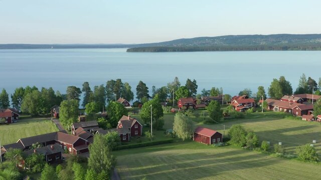 Swedish village red house drone shot. Aerial view lake typical wooden homes
