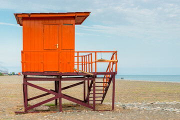 Red rescue tower on an empty beach in the early morning