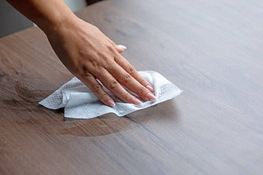 Woman cleaning office or home table surface with wet wipes stock photo