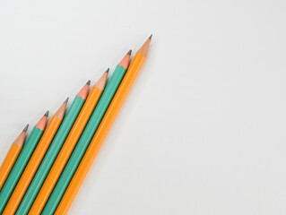 A set of simple pencils lined with a ladder on a white table surface
