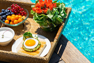 tray with assorted breakfast meal and drinks near swimming pool