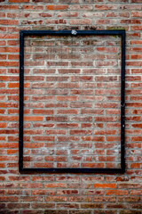 Naklejka premium Black metal frame for advertisement on brick wall