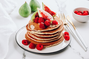 Homemade classic american pancakes with almond, fresh raspberries and figs