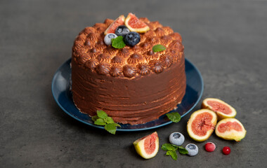 cheesecake in chocolate glaze and figs on dark gray background