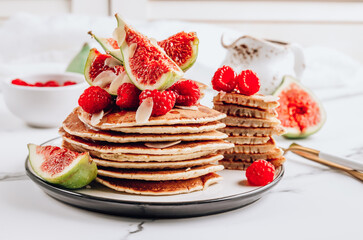 Homemade classic american pancakes with almond, fresh raspberries and figs