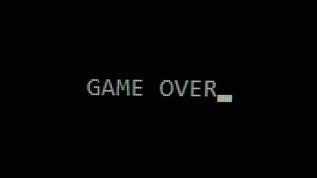 Typing of phrase Game over text on black computer screen 4K Ultra HD footage. 