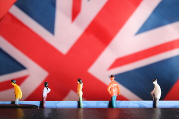 social distancing coronavirus covid-19 concept background of figures in Queue with copy space union jack British UK flag