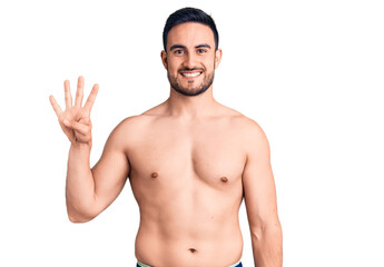 Fototapeta premium Young handsome man wearing swimwear showing and pointing up with fingers number four while smiling confident and happy.