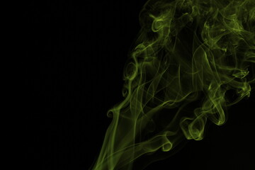 yellow smoke from incense on a black background