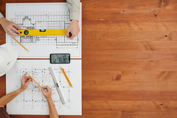 Overview of hands of contemporary engineers or builders making new sketches