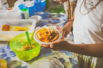 Woman serving vatapa; Brazilian Street food in the streets of Rio de Janeiro, Brazil. Vacation experience exotic food and culture travel destination concept.