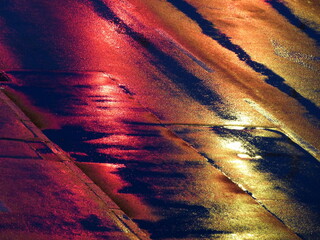 Red and yellow cross light reflection in wet street 