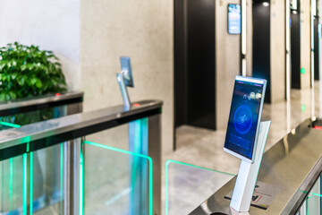 turnstile gate in office building with digital facial scaner.