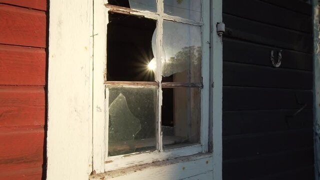 Broken window on old red barn countryside farm storage house. Abandoned stall