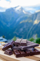 Handmade pure dark swiss chocolate and Alpine mountains on background